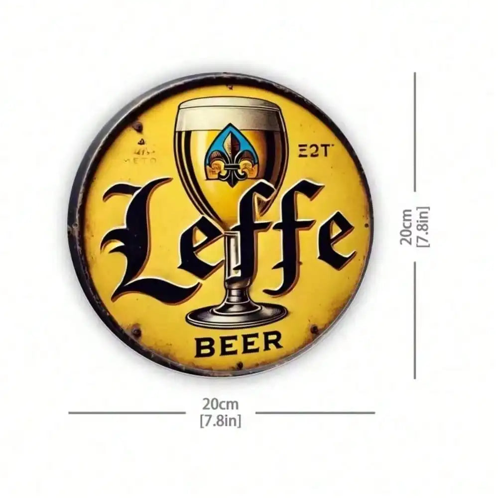 A vintage metal tin sign featuring a stylized golden beer glass design and the word Leffe Beer on a yellow background.
