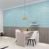 A modern interior featuring a light blue textured brick wall panel and a white desk setup with a pendant light.