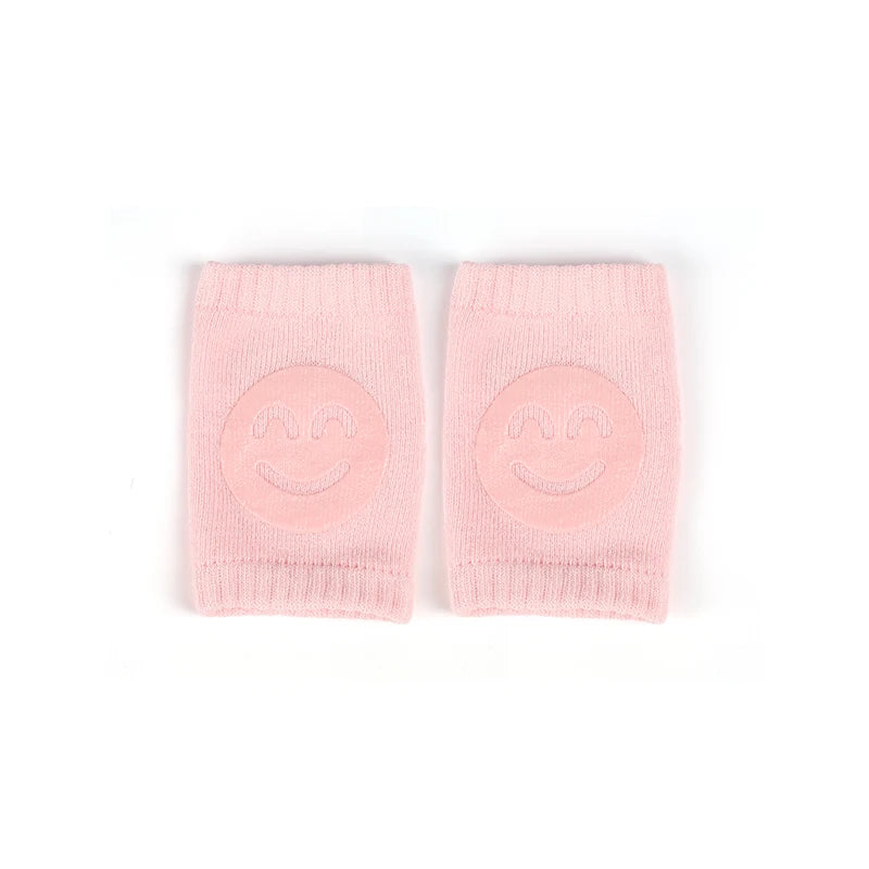 A pair of pink knitted knee pads designed for crawling infants.