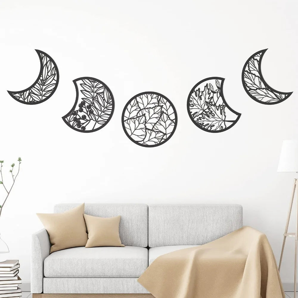 Black wooden moon phase wall art featuring various crescent and circle shapes on a white wall above a sofa.
