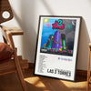 A framed poster featuring the album art for Lee Torres titled Las 3 Torres with a vibrant cityscape and musical elements.