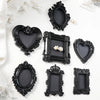 A collection of black resin wall decor pendants in various heart and rectangular shapes with ornate edges.