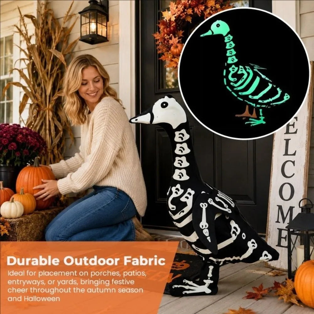 A black and white skeleton goose lawn decor statue placed on a wooden porch with autumn foliage.