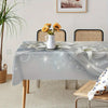 Elegant lily flower rectangular tablecloth displayed on a wooden table with a vase of yellow flowers.