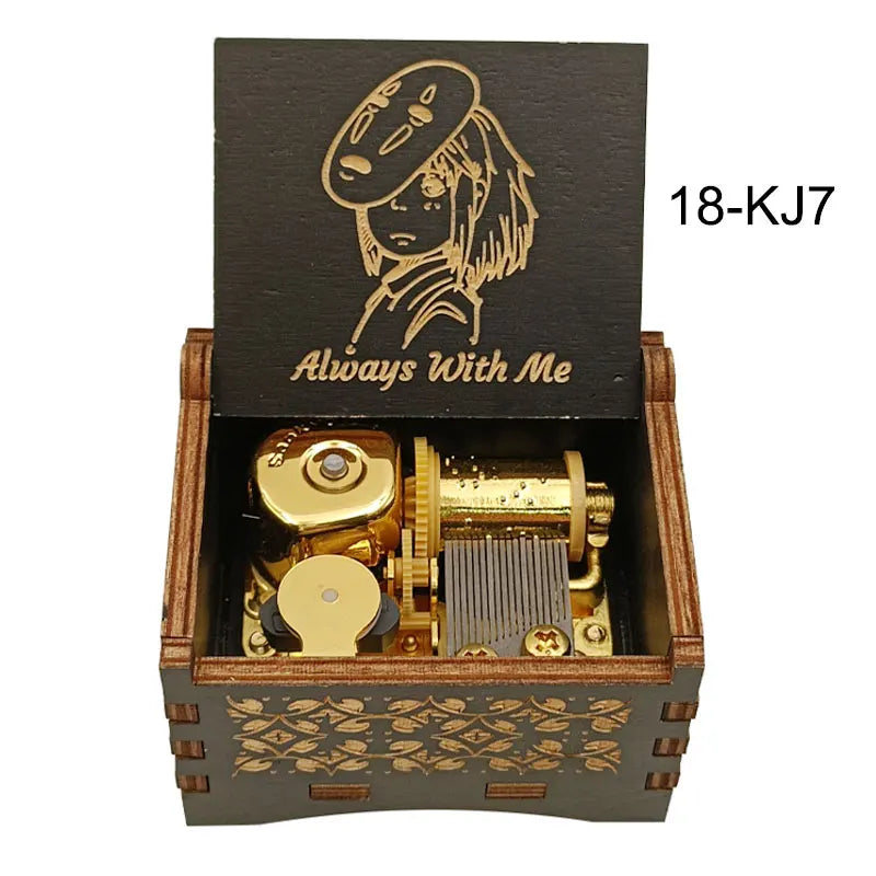 A wooden box containing a brass music box with a gold-colored mechanism and an anime character design.