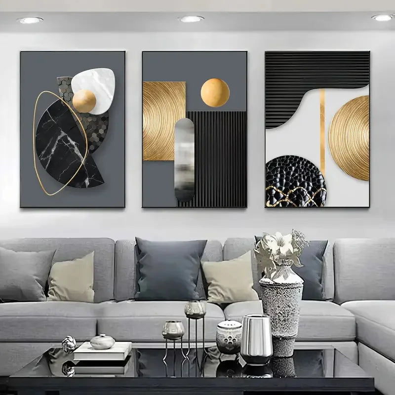 A set of three abstract marble geometry canvas art pieces featuring gold, black, and white tones displayed on a gray sofa.