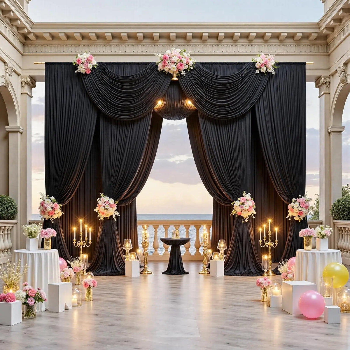 Elegant black draped fabric curtains forming a backdrop for an event with gold and pink floral accents.