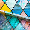 Rainbow stained glass window film being applied to a surface, showing vibrant colors and patterns.
