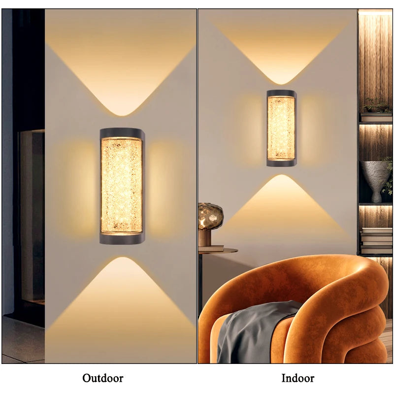 An outdoor wall sconce featuring a crystal-like textured glass shade mounted on a white wall with an upward-pointing light be