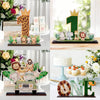 A wooden jungle animal party ornament featuring various animals and a crown, displayed on a white stand.