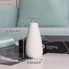 A white ceramic vase is shown on a dark surface with dimension lines indicating its height and diameter.
