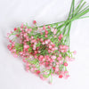 A bunch of pink artificial baby's breath flowers with green stems.