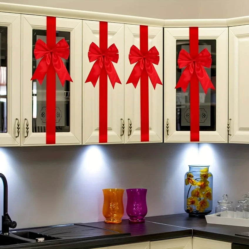 Decorative red ribbon bows on white cabinet doors with glass inserts.