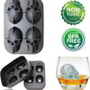 A set of silicone ice molds shaped like skulls, spheres, and diamonds used for freezing drinks.