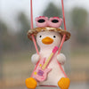 A cute pink anime duck ornament wearing a straw hat and sunglasses is suspended by a pink string.