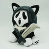 A plush toy resembling a cat with black and white markings wearing a dark hood and holding a blade.