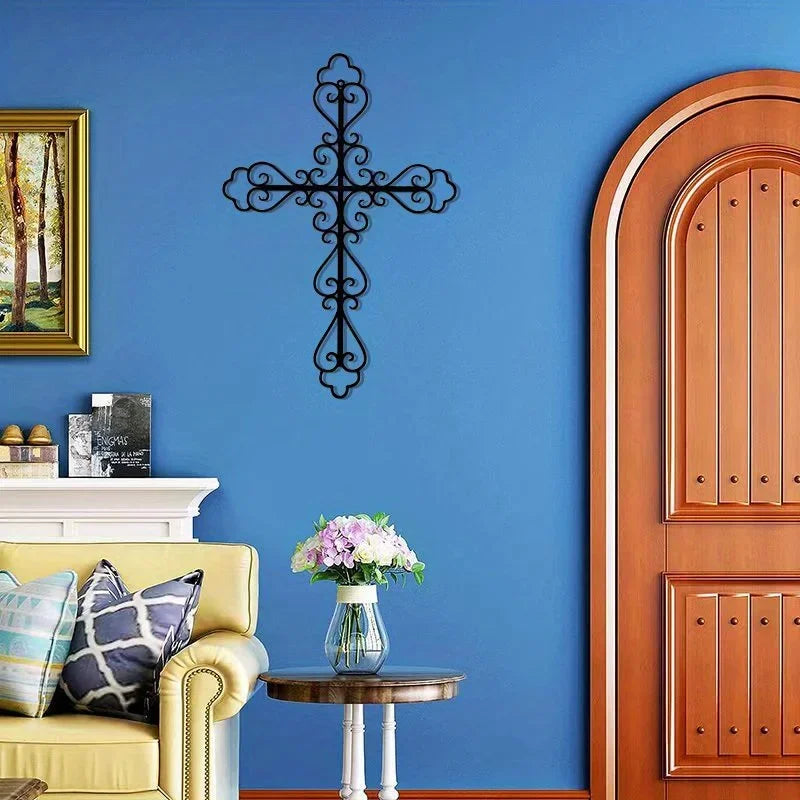 A dark metal cross wall decor is mounted on a blue wall next to a wooden door and a yellow sofa.