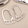 A silver stainless steel keychain with a multi-loop design is shown against a light background.