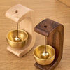 A wooden doorbell featuring a copper bell mounted on a wooden base.