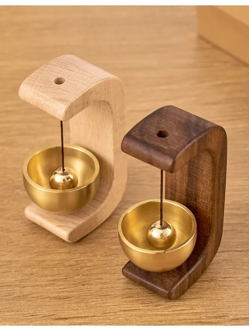 A wooden doorbell featuring a copper bell mounted on a wooden base.