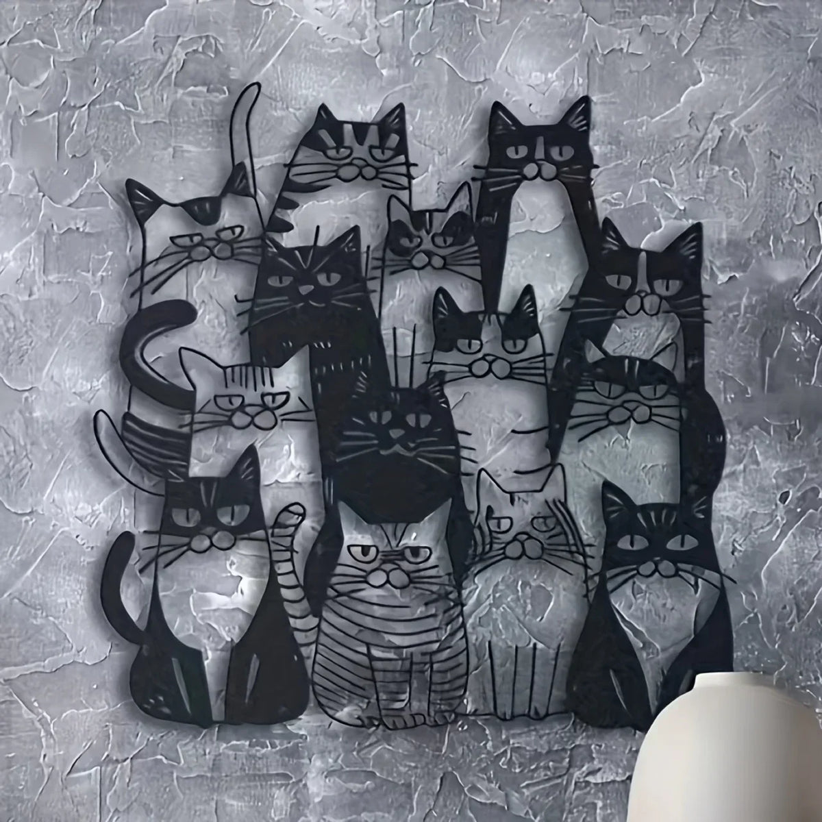 A collection of black cats in various poses and styles displayed as metal wall art on a gray textured background.