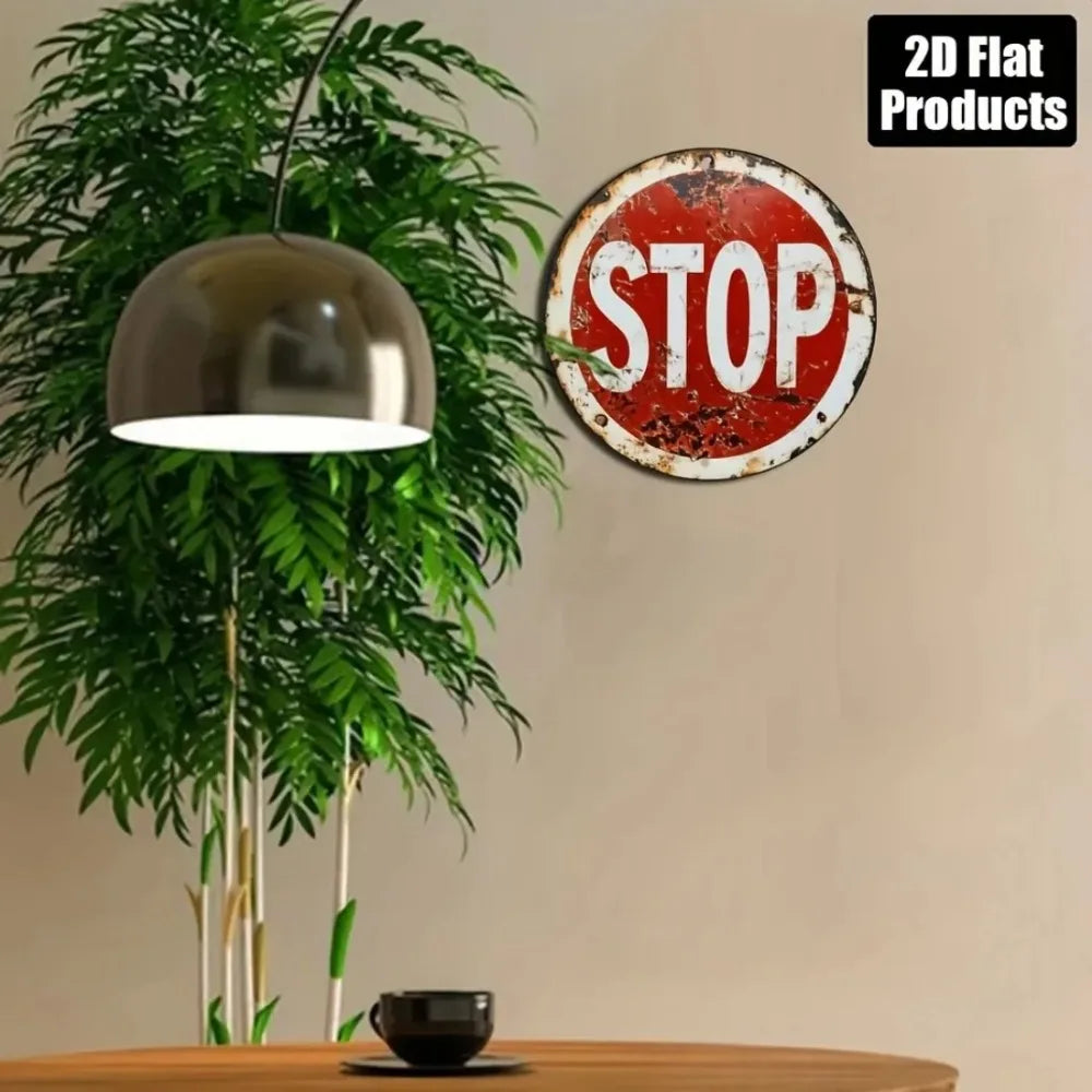 Vintage metal round stop sign wall decor with a red background and white text on a light beige wall.