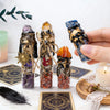 Three glass bottles filled with natural crystals and raw stones displayed on a white surface.