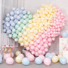 A large balloon bouquet featuring pastel macaron balloons in a rainbow gradient of blue, green, yellow, and pink.