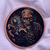 A dark copper challenge coin featuring a grim reaper design.