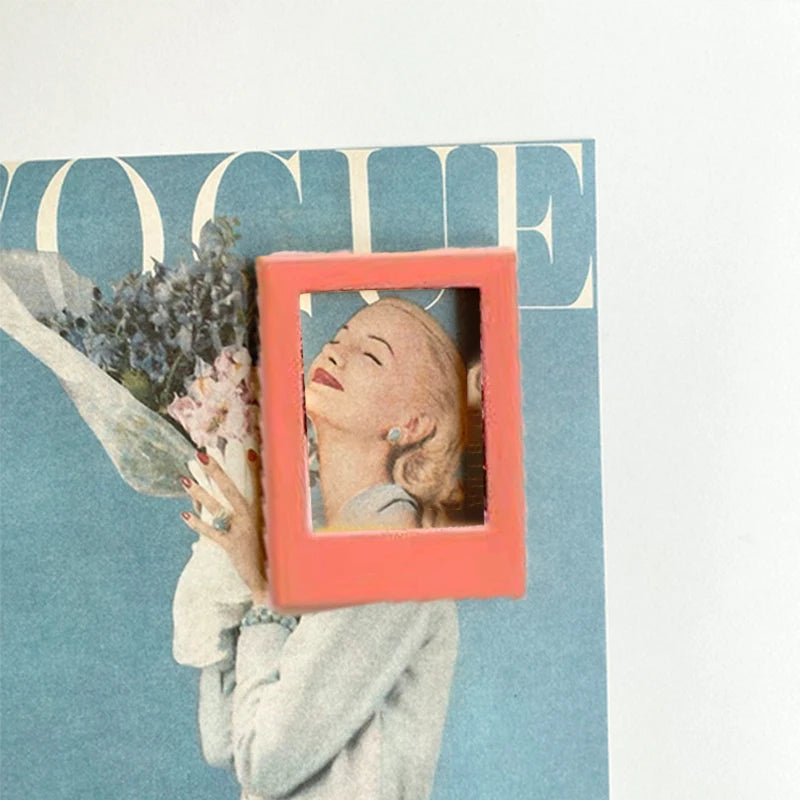 A close-up of a pink magnetic photo frame displaying a woman's face against a teal background.