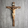 A resin figurine of Jesus on a wooden cross with the inscription INRI, used for home and office decor.