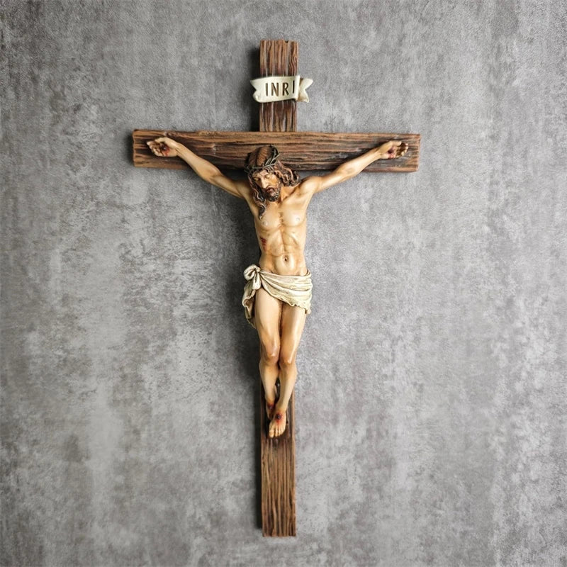 A resin figurine of Jesus on a wooden cross with the inscription INRI, used for home and office decor.