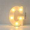 A glowing yellow LED letter light shaped like the letter G, used for room or party decor.