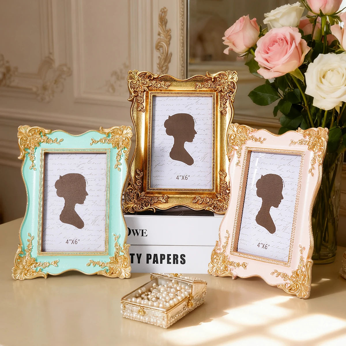 A set of three ornate gold and pastel-colored photo frames displaying silhouette portraits on white backgrounds.
