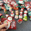A collection of festive Santa Claus and snowman figurines for Christmas decor arranged on a dark surface.
