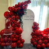 A large arrangement of deep burgundy latex balloons displayed against a white background.