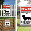 A set of durable metal tin signs warning to beware of property patrolled by a Dachshund security dog.