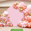 A pink balloon arch backdrop decorated with gold and peach balloons for an event