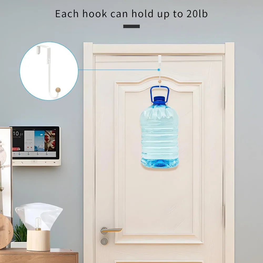 A clear water bottle is hanging on a white door using an over-the-door hook.