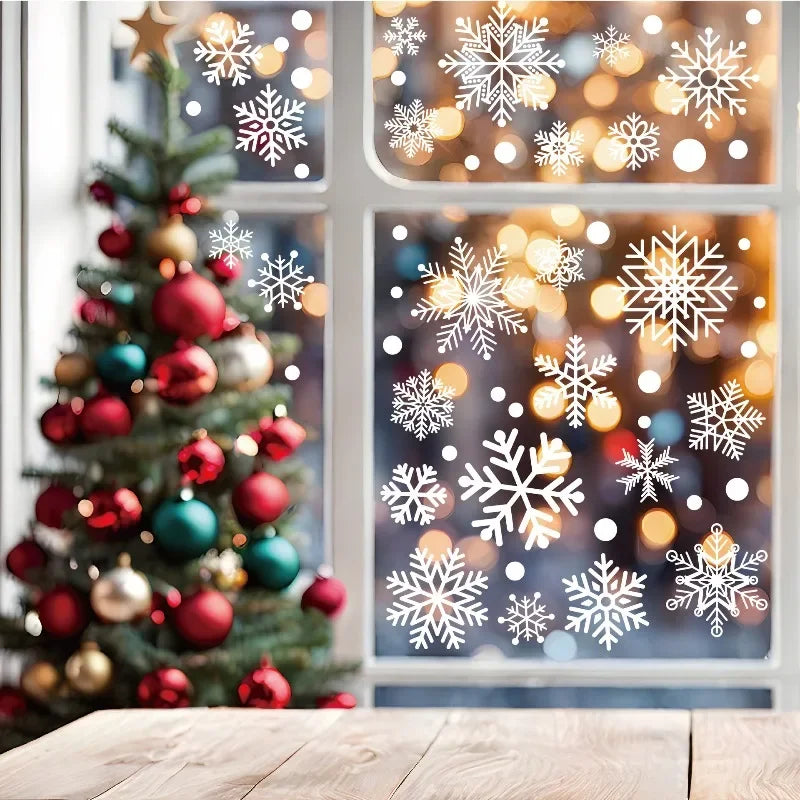 A decorated Christmas tree stands in front of a window featuring snowflake window clings and bokeh lights.