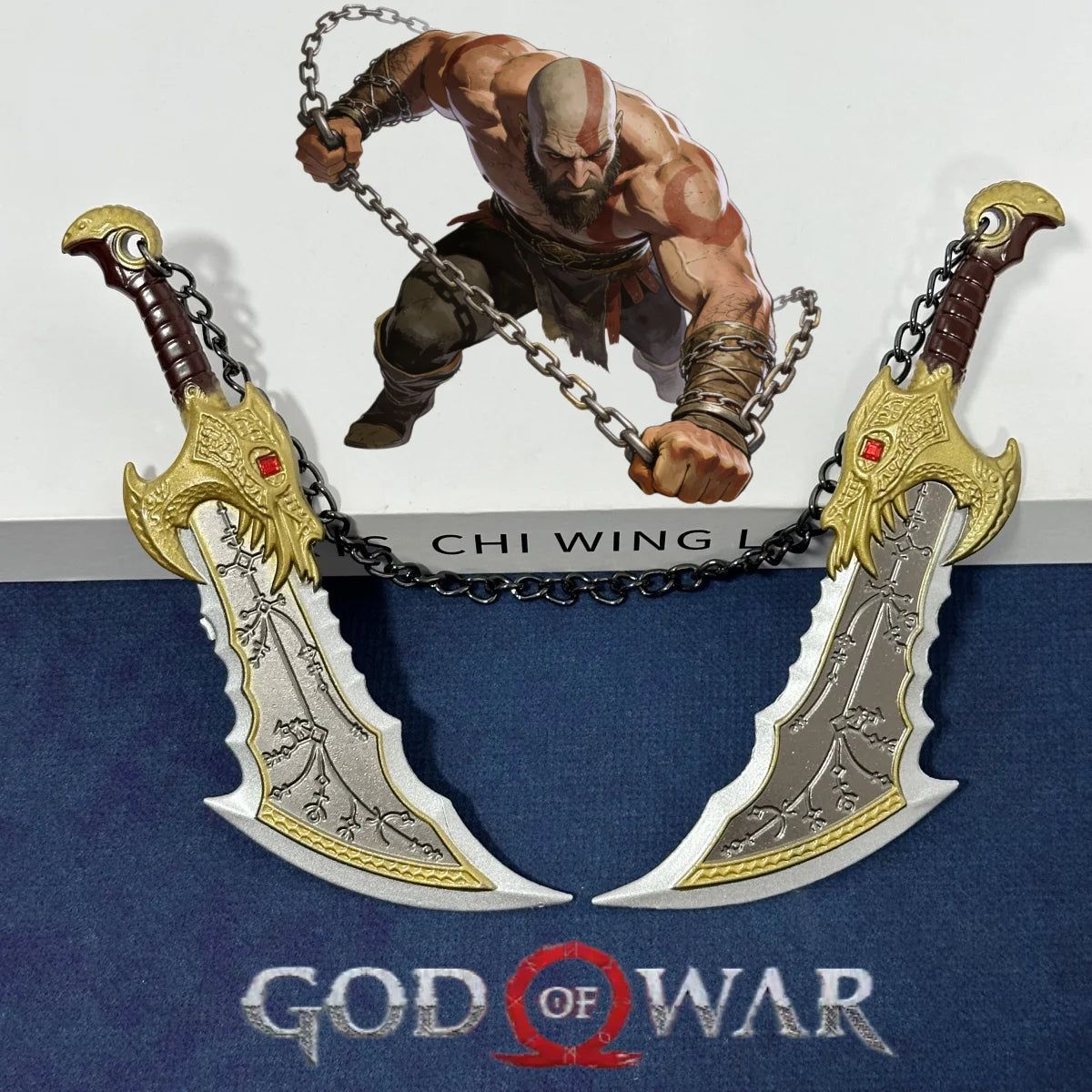 A miniature collectible sword of Kratos's katana is displayed above the God of War logo.