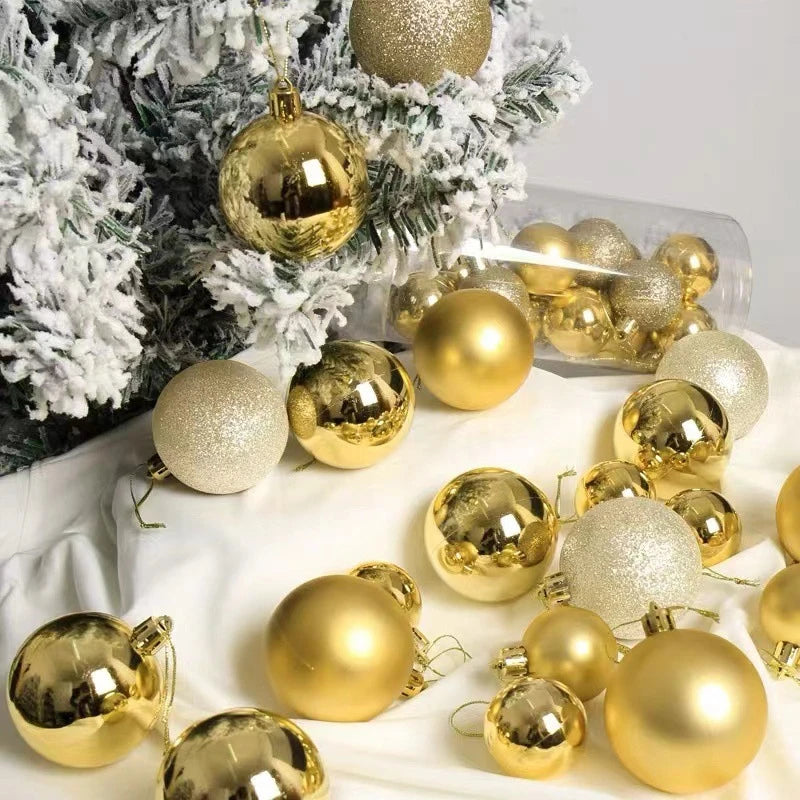 A collection of gold and silver festive Christmas tree ornament balls displayed on a white cloth.