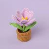 Handcrafted crochet purple tulip flower with yellow center growing in a brown pot