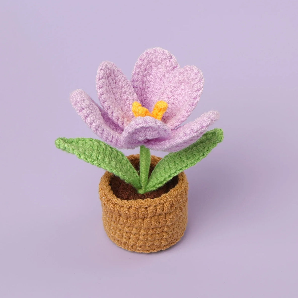 Handcrafted crochet purple tulip flower with yellow center growing in a brown pot