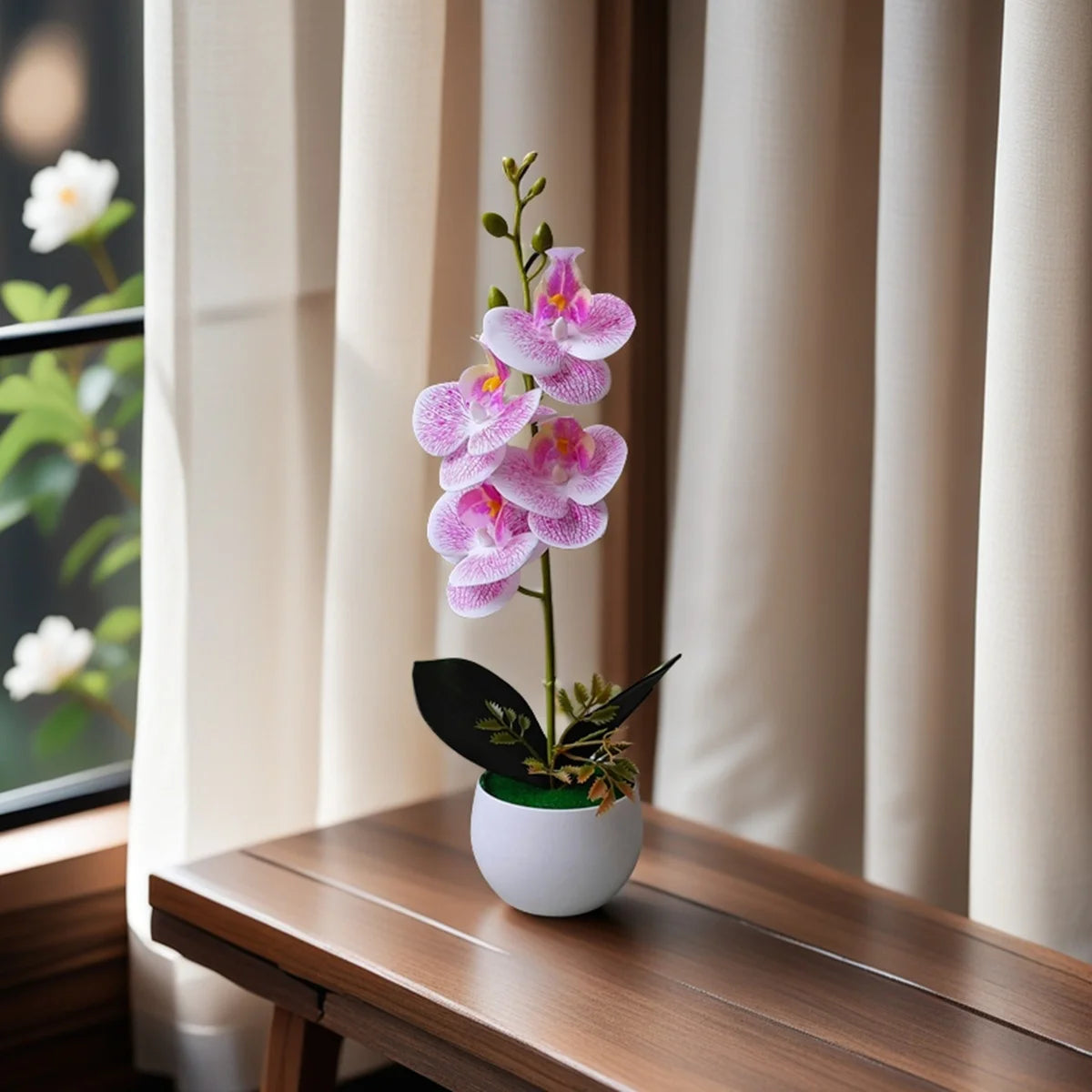 A pink orchid plant in a white pot sits on a wooden table next to a window.