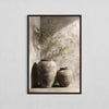 A painting featuring an olive tree in a vase against a light background.