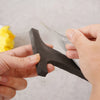 Hands are holding a black acrylic mirror letter wall sticker, demonstrating its shape and size.