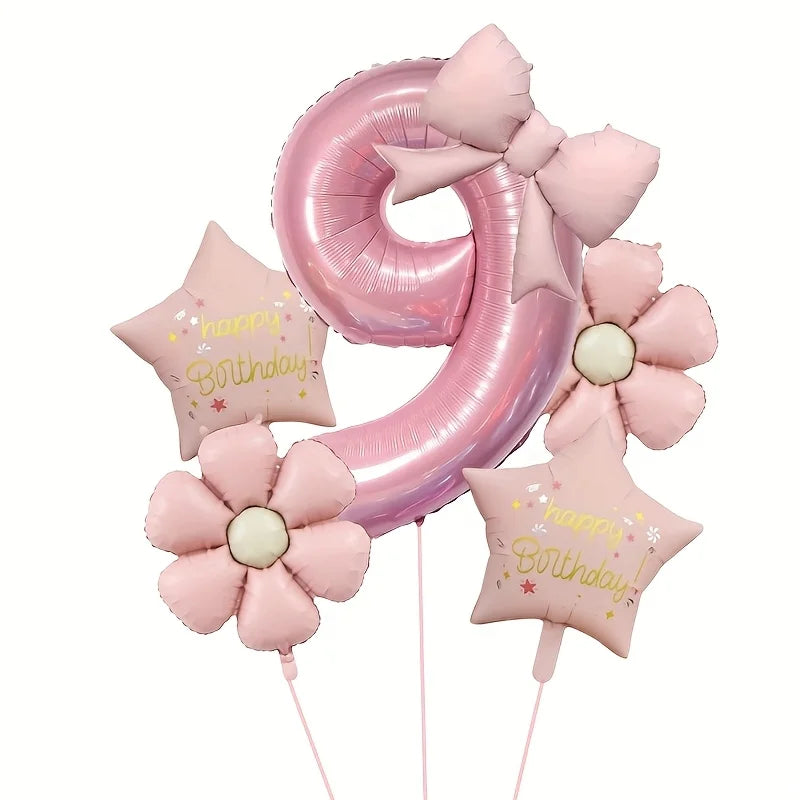 A large pink foil balloon shaped like the number 9 is decorated with pink flowers and stars for a birthday celebration.