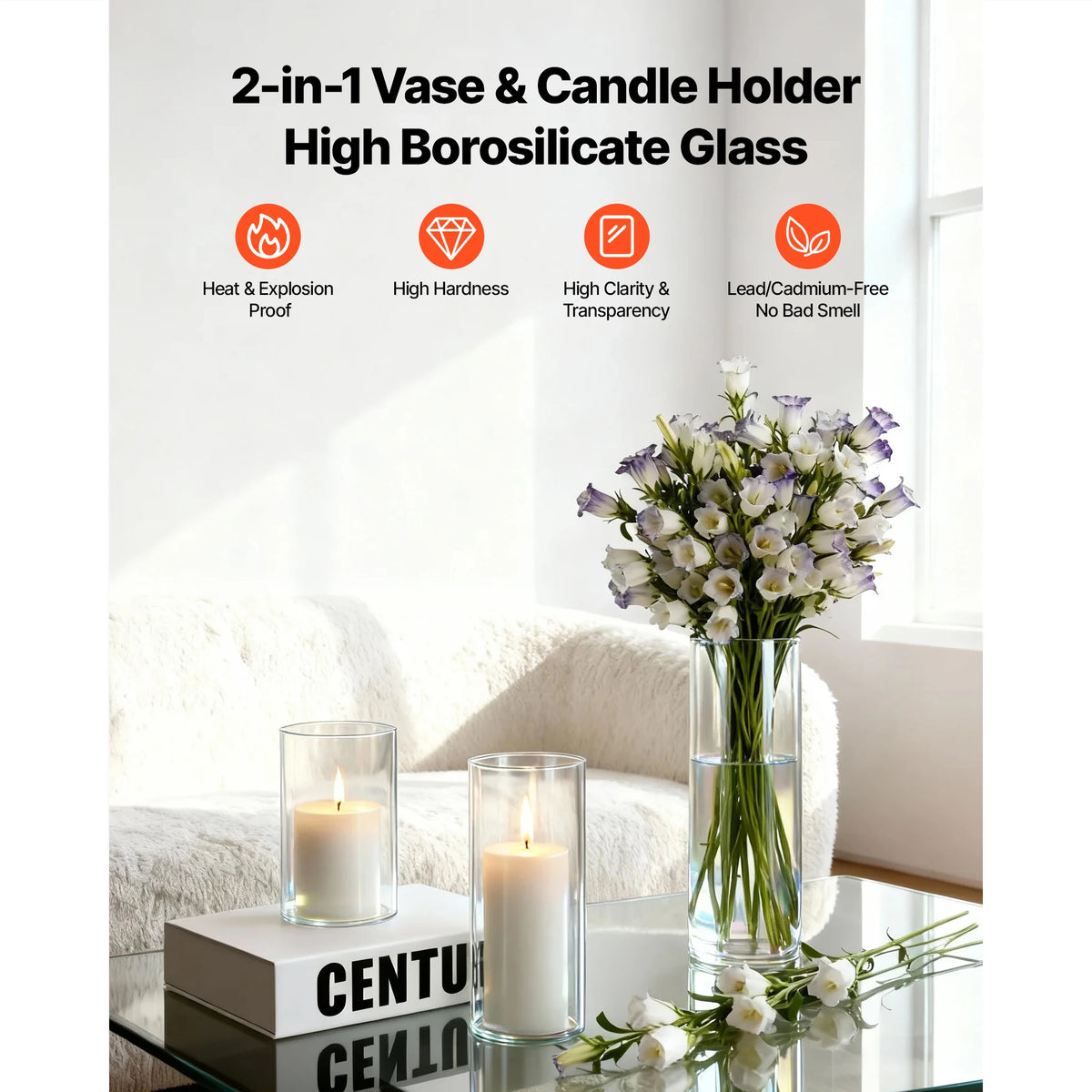 A clear glass cylinder vase with a pillar candle is displayed on a glass table next to a bouquet of white flowers.