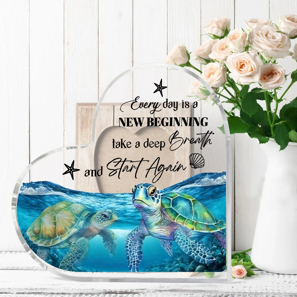 Acrylic tabletop decor featuring a blue sea turtle illustration with text encouraging a new beginning.